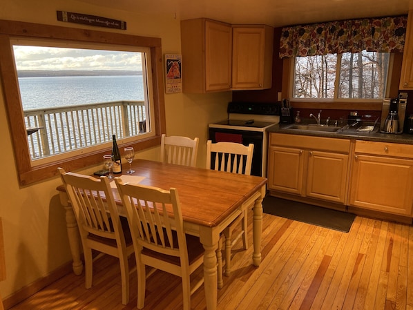 Eat in kitchen, fully stocked with plates, coffee maker, pans, and silverware.