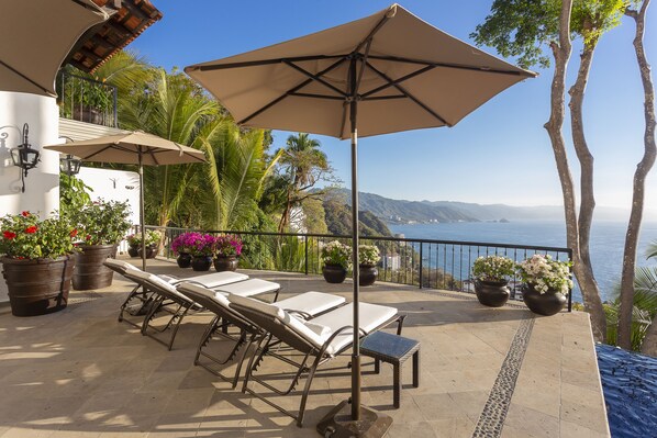 Extensive sunbathing terrace with infinity pool and stunning bay views