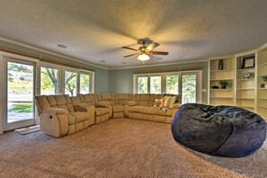 The plush sectional rests beside the flat-screen Smart TV and backyard access.