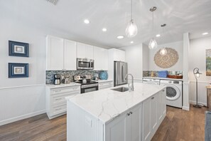 Large kitchen island for prep with built in pantry space in the island