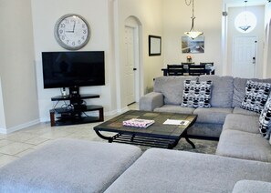 Large sectional couch with updated beach decor and flatscreen tv. and Roku. 