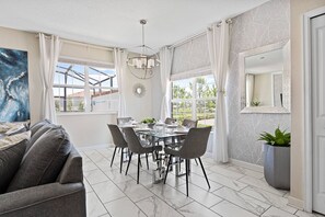 Dining room in a very well lit area and bright white curtains