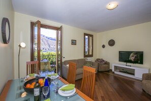 Zona de estar con mesa de comedor separada y televisión montada en la pared