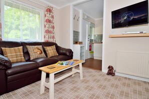 Living room with comfy three-seater sofa and flat screen TV with Freesat