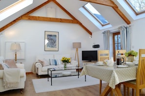 The light, sunny open-plan living area on the first floor soars into the eaves 