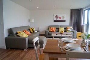 Open plan lounge/kitchen area with two comfy leather sofas (one is a sofa bed)