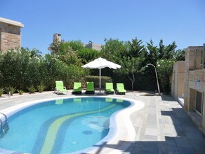 Sun loungers by the pool and outdoor shower. 