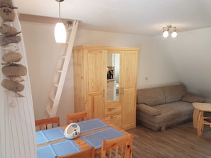 Wohnbereich mit Eßtisch und Leiter zum Schlafboden