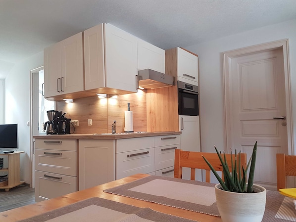 Küche mit Induktionskochfeld und Backofen mit Mikrowelle