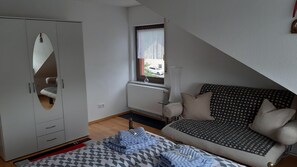 Couch und großer Schrank in Schlafzimmer 1 mit Doppelbett