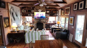 Main room. Wood covered walls, floors and ceilings, opening to lake view porch
