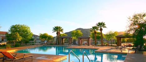 Beautiful pool area, tons of lounge chairs, mountain view, and palm trees!