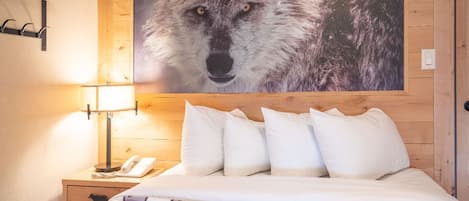 A bedroom featuring a striking wall mural and plush bedding.