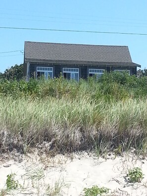 Standing on the beach, in front of the dune, looking up at the house