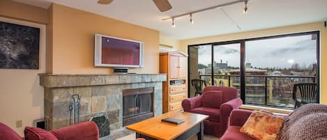The living room features a stunning stone wood burning fireplace.