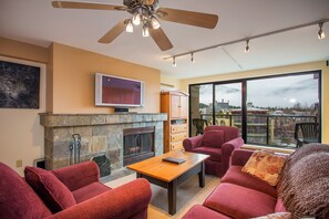 The living room features a stunning stone wood burning fireplace.