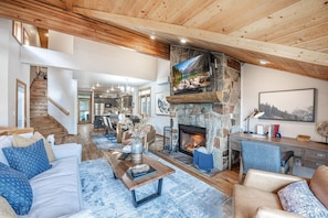 Get cozy in the professionally designed living room, complete with ample comfortable seating and a gas fireplace adorned with a stone surround, evokin