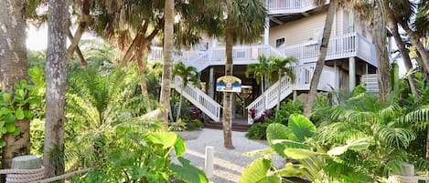 Tropical landscaping, Key West style home with grand double staircase entrance.