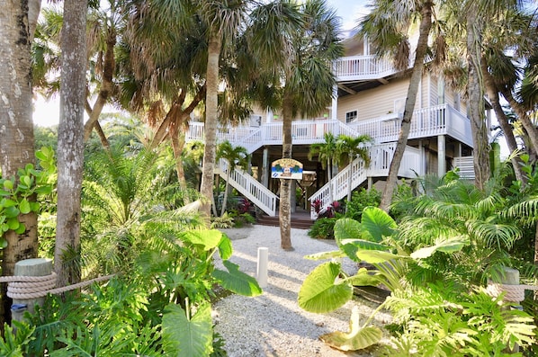 Tropical landscaping, Key West style home with grand double staircase entrance.