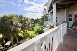 Wraparound 2nd floor balcony overlooks tropical property with 40+ palm trees.