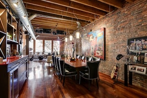 Wet bar, wine fridge, dining table, exposed brick and beam and unique art