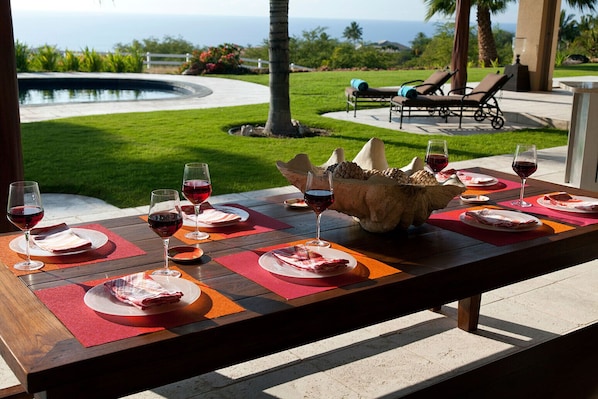 Outdoor dining under covered lanai with ocean and pool views.  Ideal climate 