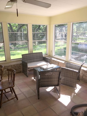 Partial view of screened in sun porch and backyard