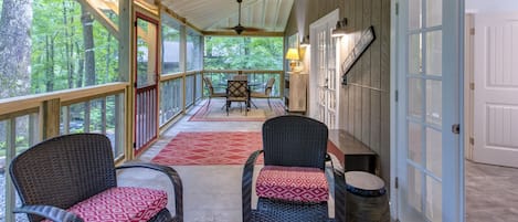 Roomy screened porch with comfortable seating and outside dining area