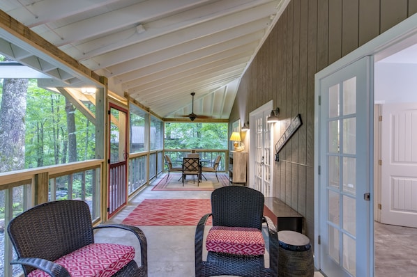 Roomy screened porch with comfortable seating and outside dining area