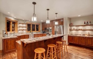 Gourmet open kitchen, granite countertops and fully-equipped, and breakfast bar seating