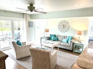 Family room with view of the deck. A large TV is across from the sofa.