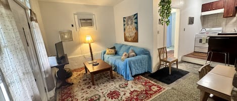 Living area with front door to left and kitchen to right.