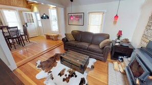 Living room with wood burning fireplace and leather sleeper sofa