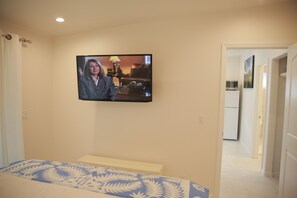 Bedroom has large wall mounted flat screen TV