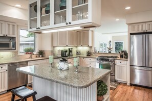 Bright modern family kitchen looks into large family room. Bar seating for 2.