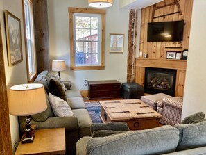 First floor living room with fireplace and smart tv.