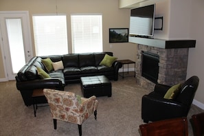 Living room with leather sectional, huge TV with Dish and BluRay player