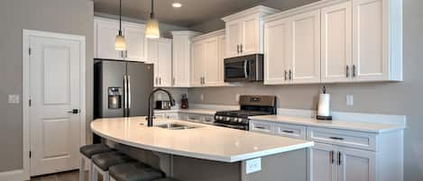 The gourmet kitchen features designer cabinets & delux white quartz countertops.