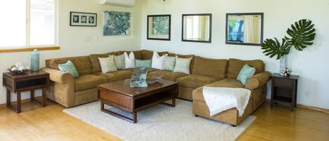 livingroom w/ large sectional, flat screen tv, cable, ceiling fans and AC