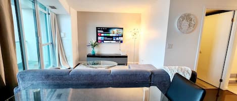 Living room with smart tv and ceiling to floor glass windows