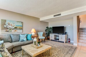 Living Room with flat screen TV facing entryway stairs