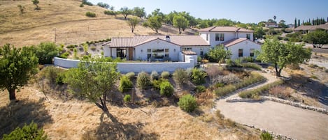 A beautiful Spanish style modern home surrounded by drought tolerant landscaping