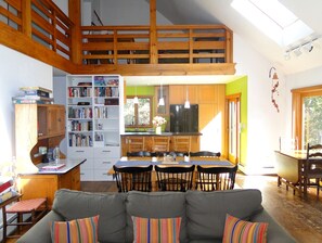 Living and dining areas plus kitchen as seen from the fireplace. Loft above