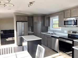 Kitchen features fridge, stove, microwave, dishwasher and island