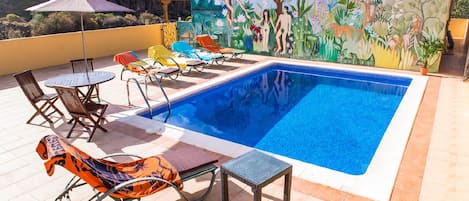 private Heated swimming pool on 100 sq m. terrace with dining table and seating.