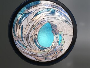 enjoy the custom stained glass window of a wave