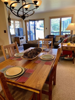 Large dinning table with six chairs, and counter seating with tw kitchen stools.