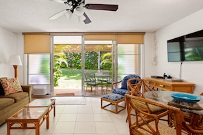 Living area looks out to lanai and lush landscaping