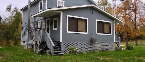 The cabin, set back from the road in the middle of the large open yard.  