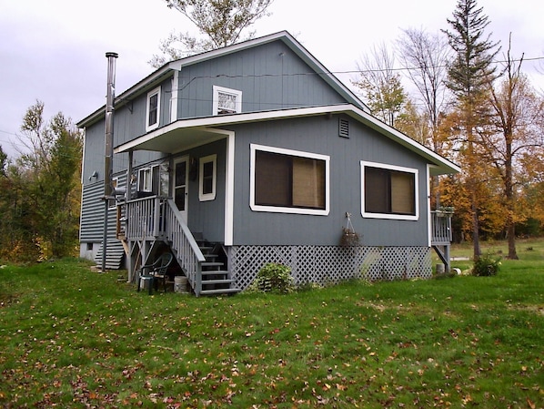 The cabin, set back from the road in the middle of the large open yard.  